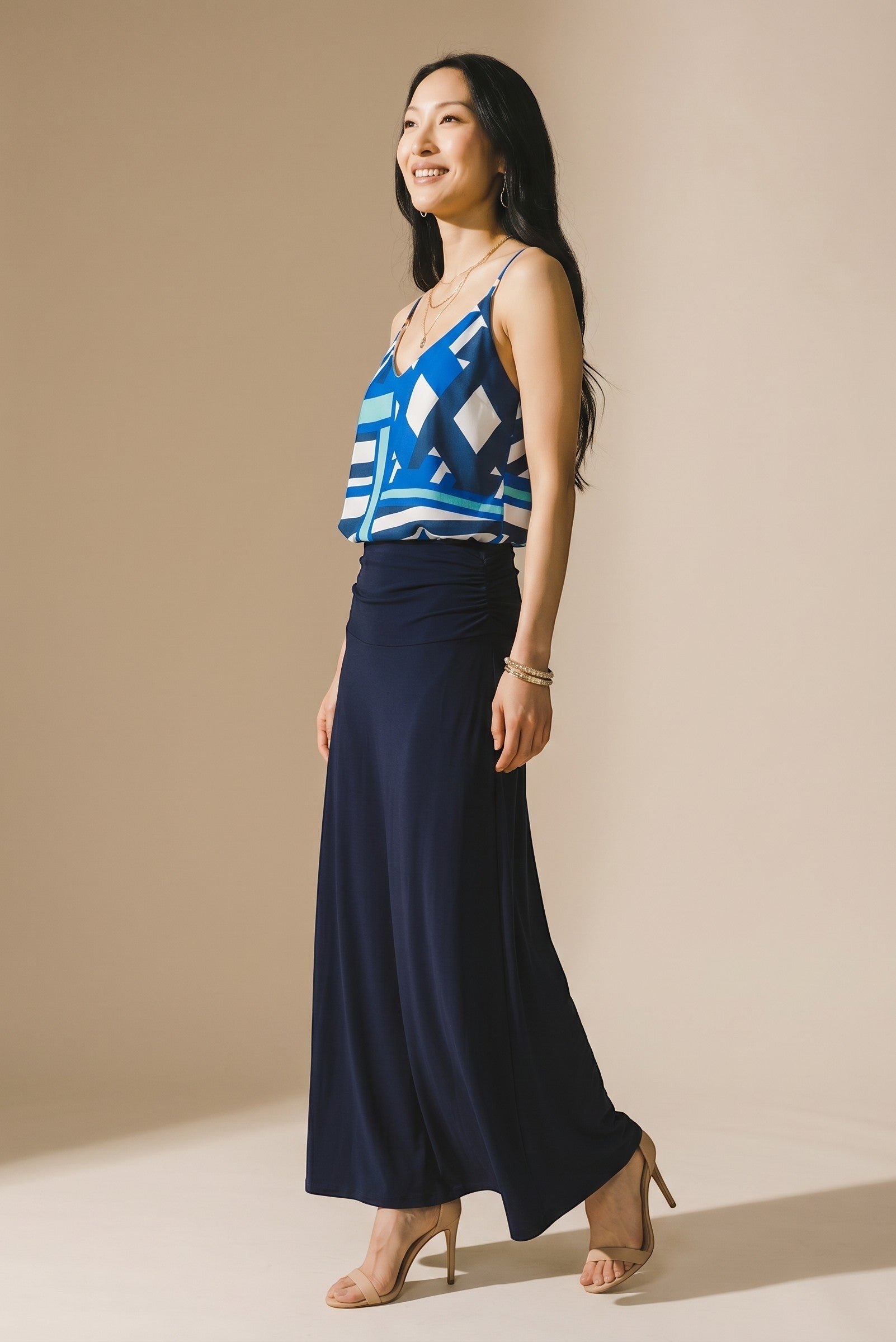 Osanna Creazione blue geometric print camisole with thin straps and a V-neck, paired with a navy blue ruched maxi skirt.