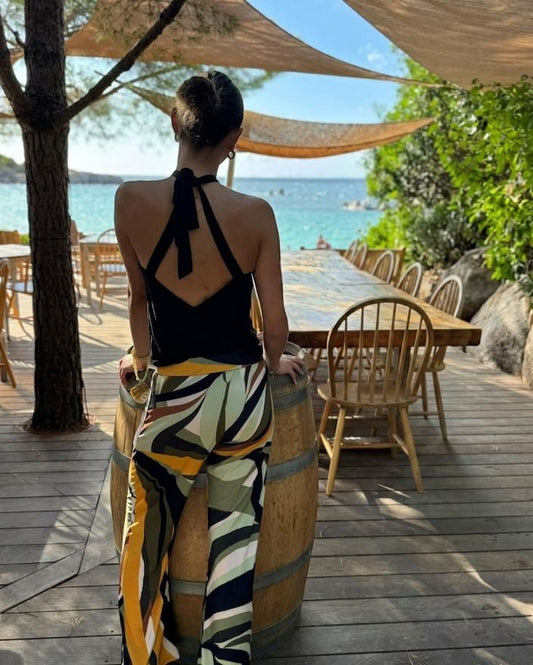 Osanna Creazione Cairon fluid pants with abstract print in green, yellow, white, and brown. Wide leg, elasticated waist.