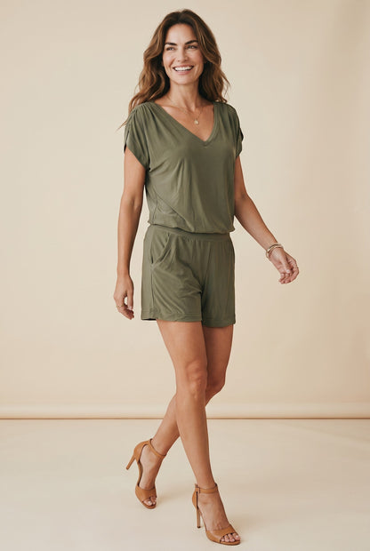 Osanna Creazione combishort fluide vert kaki, col V, dos nu, taille élastiquée, coupe short ample. Modèle sur fond neutre.