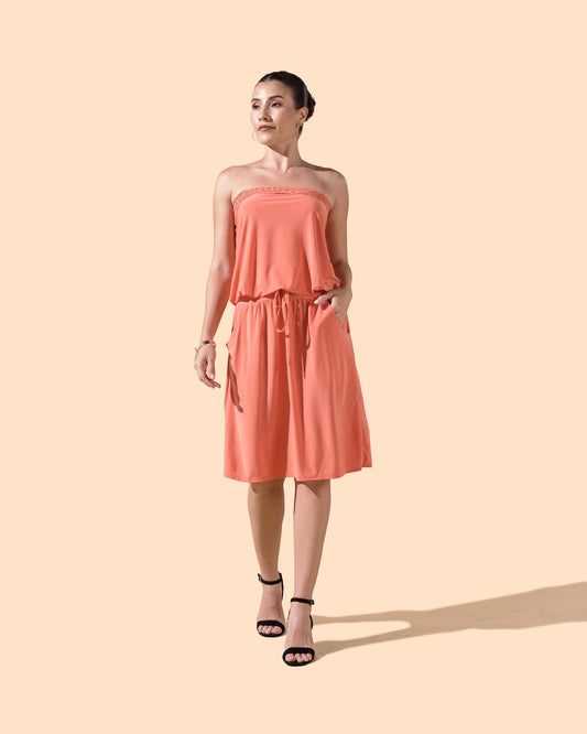 Osanna Creazione coral strapless short dress with braided bustier, blousant top, and pockets. Model is wearing black heels.