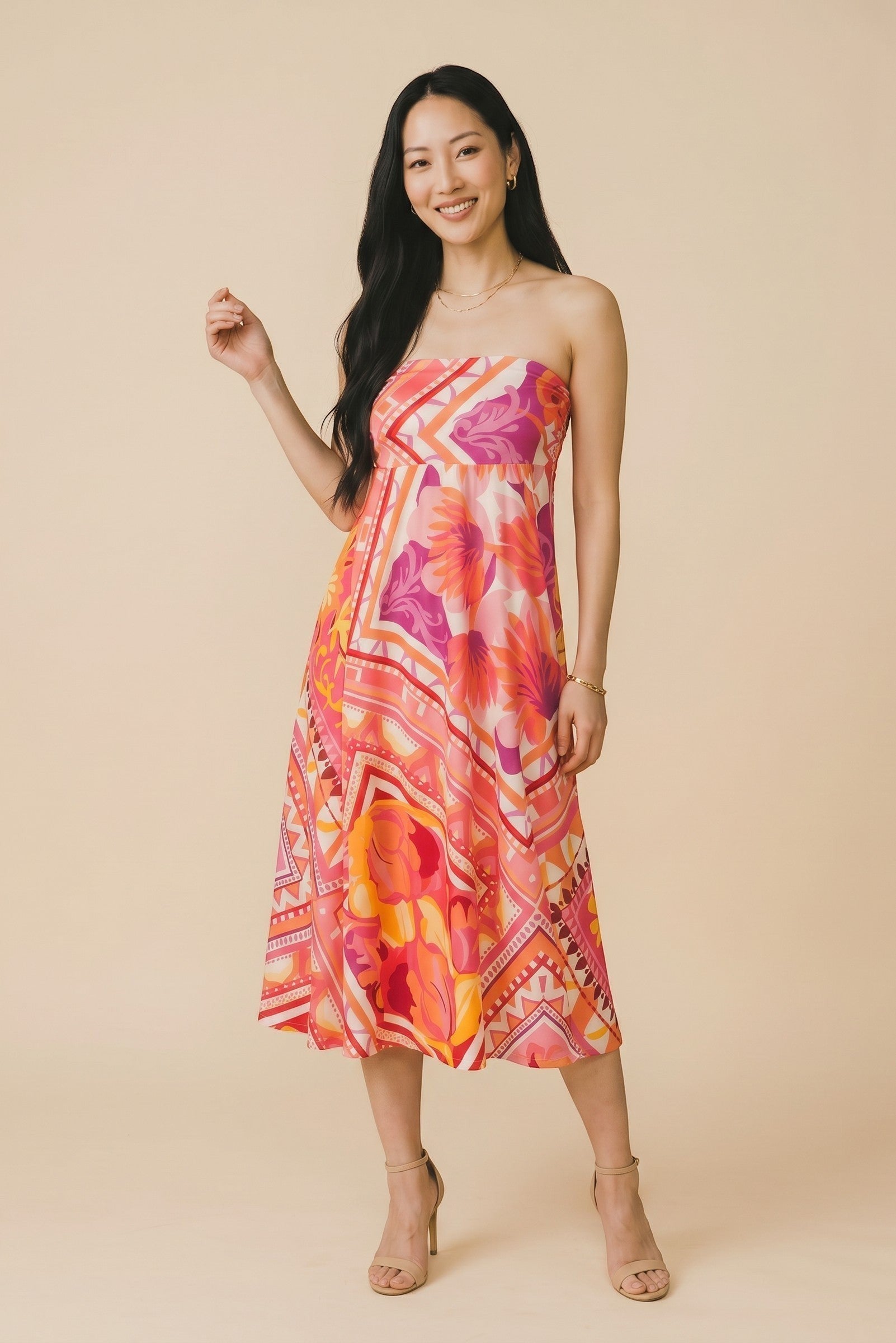 Osanna Creazione Florence strapless maxi dress in vibrant floral print with pink, orange, and purple hues. Features a bandeau top and flowing skirt.