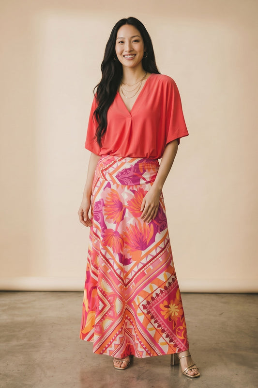 Osanna Creazione Florence maxi skirt with vibrant floral and geometric print in pink, orange, and yellow. Fluid, lightweight fabric with a comfortable bandeau waist.