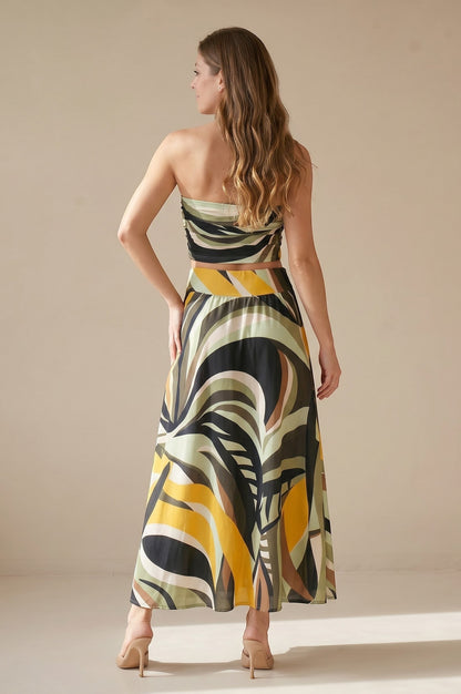 Osanna Creazione women's long flowing skirt with a bold abstract print in green, yellow, black, and brown. High-waisted with an elastic band and pockets.