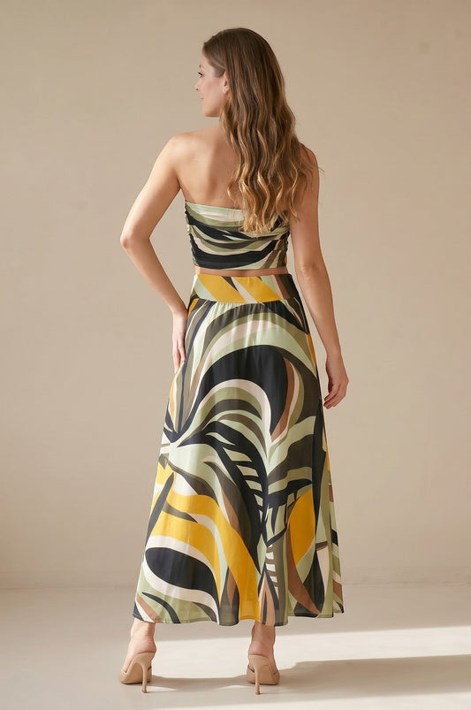 Osanna Creazione women's long flowing skirt with a bold abstract print in green, yellow, black, and brown. High-waisted with an elastic band and pockets.