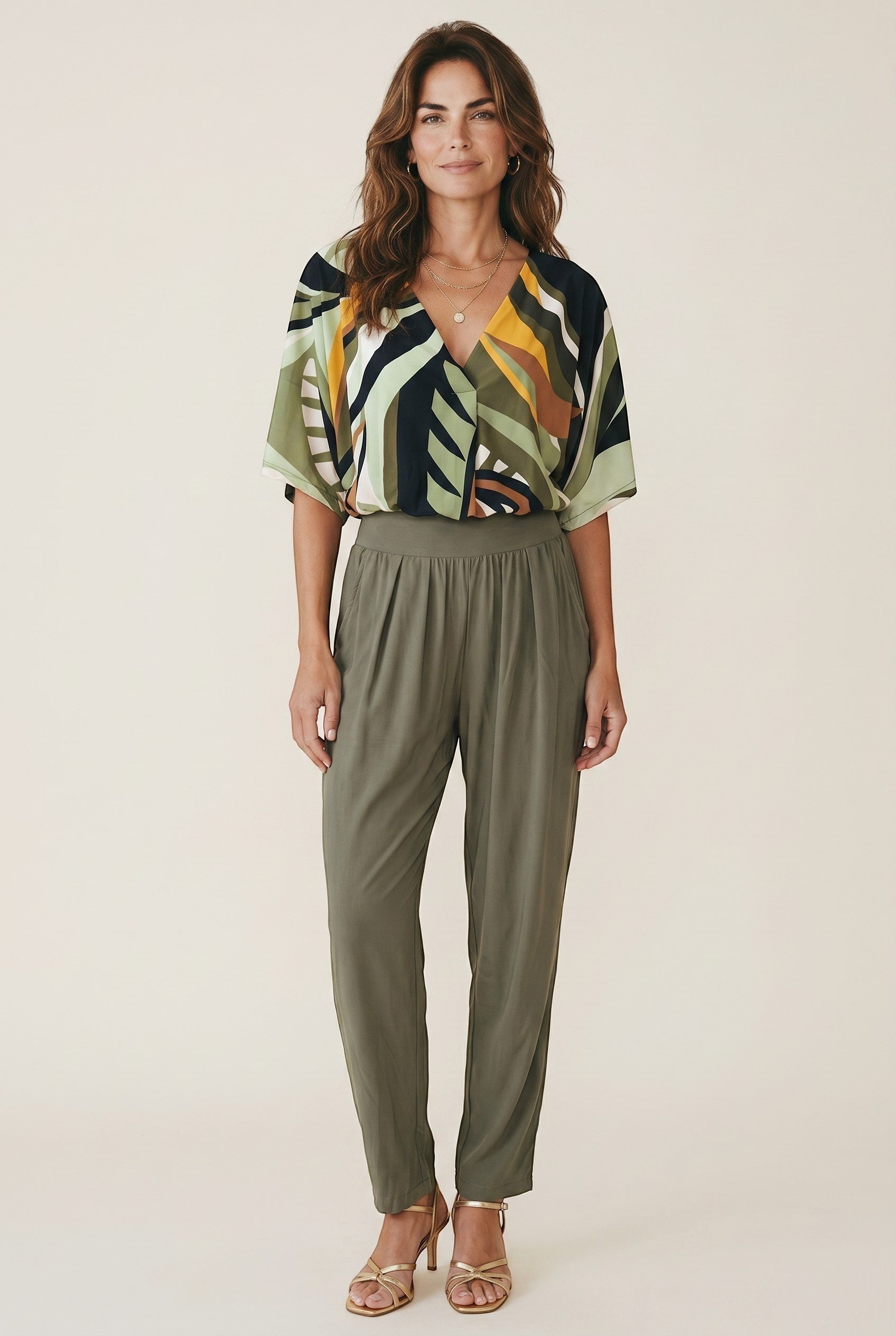 Osanna Creazione fluid olive green tapered trousers with high waist and side pockets, worn by a model.