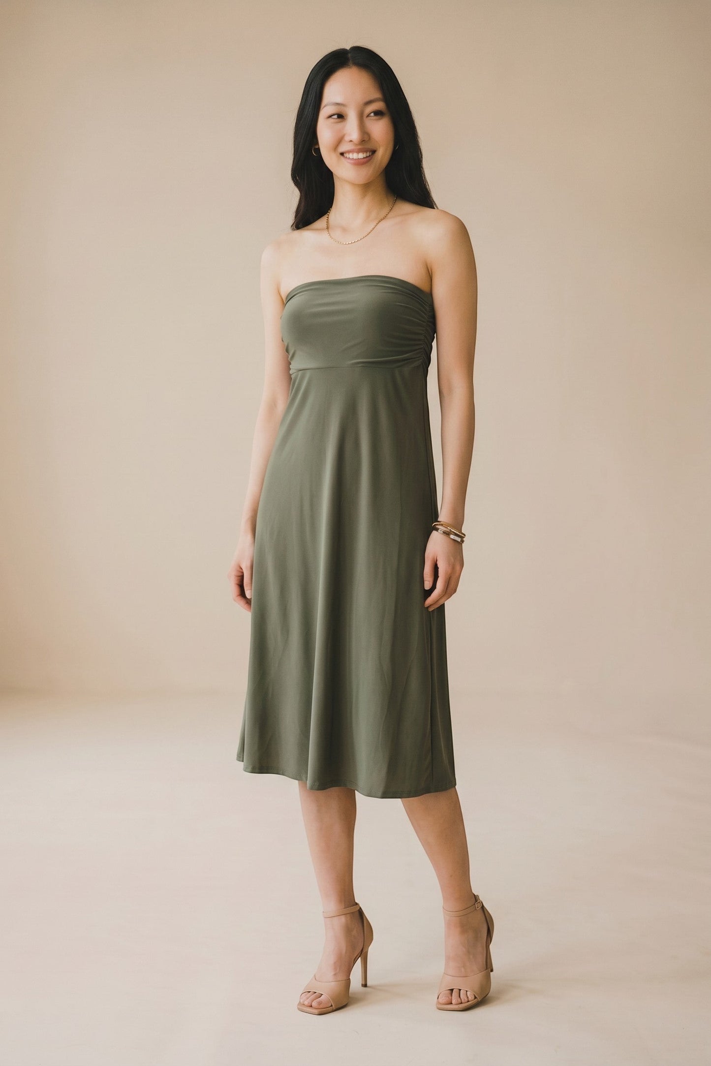 Osanna Creazione olive green strapless midi dress with ruched bust detail, worn by a model with heels.