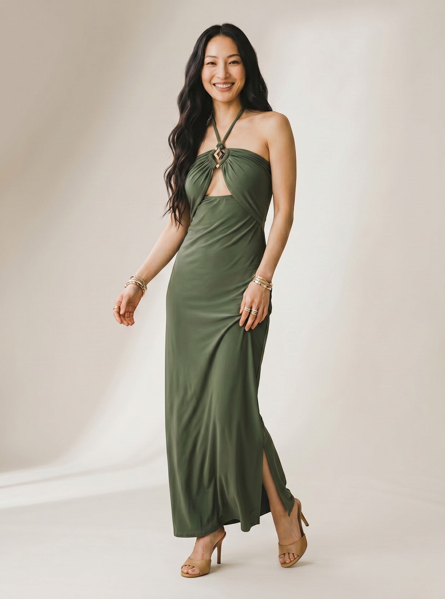Osanna Creazione robe longue verte dos nu avec découpe ventre et fente latérale, bijou géométrique doré, matière fluide.