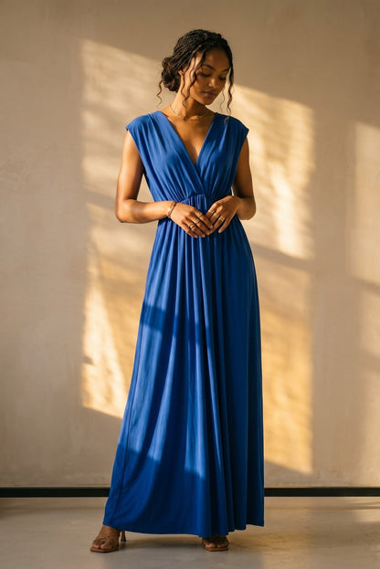 Osanna Creazione Robe longue empire bleue col V, élastique sous poitrine, coupe fluide et évasée.