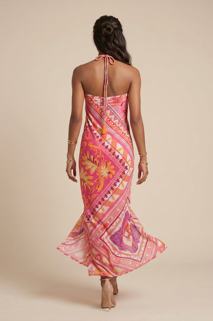 Robe longue dos nu imprimée rose et orange, avec un lien tressé à nouer et une coupe drapée. Osanna Creazione.